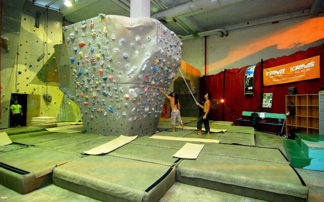 Không gian bouldering trong nhà với tường leo và lớp đệm bên dưới